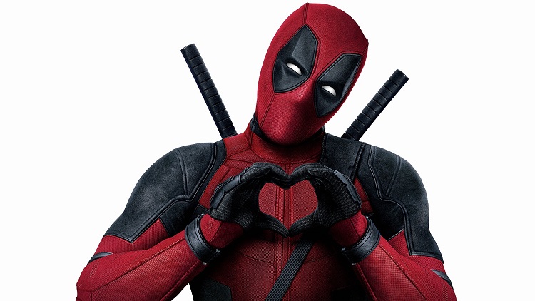 Ryan Reynolds are Deadpool making a heart symbol with his hands.