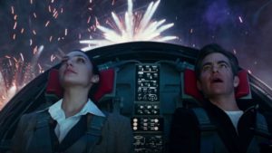 A screenshot from 'Wonder Woman 1984' featuring Gal Gadot as Diana Prince and Chris Pine as Steve Trevor watching fireworks through an airplane cockpit