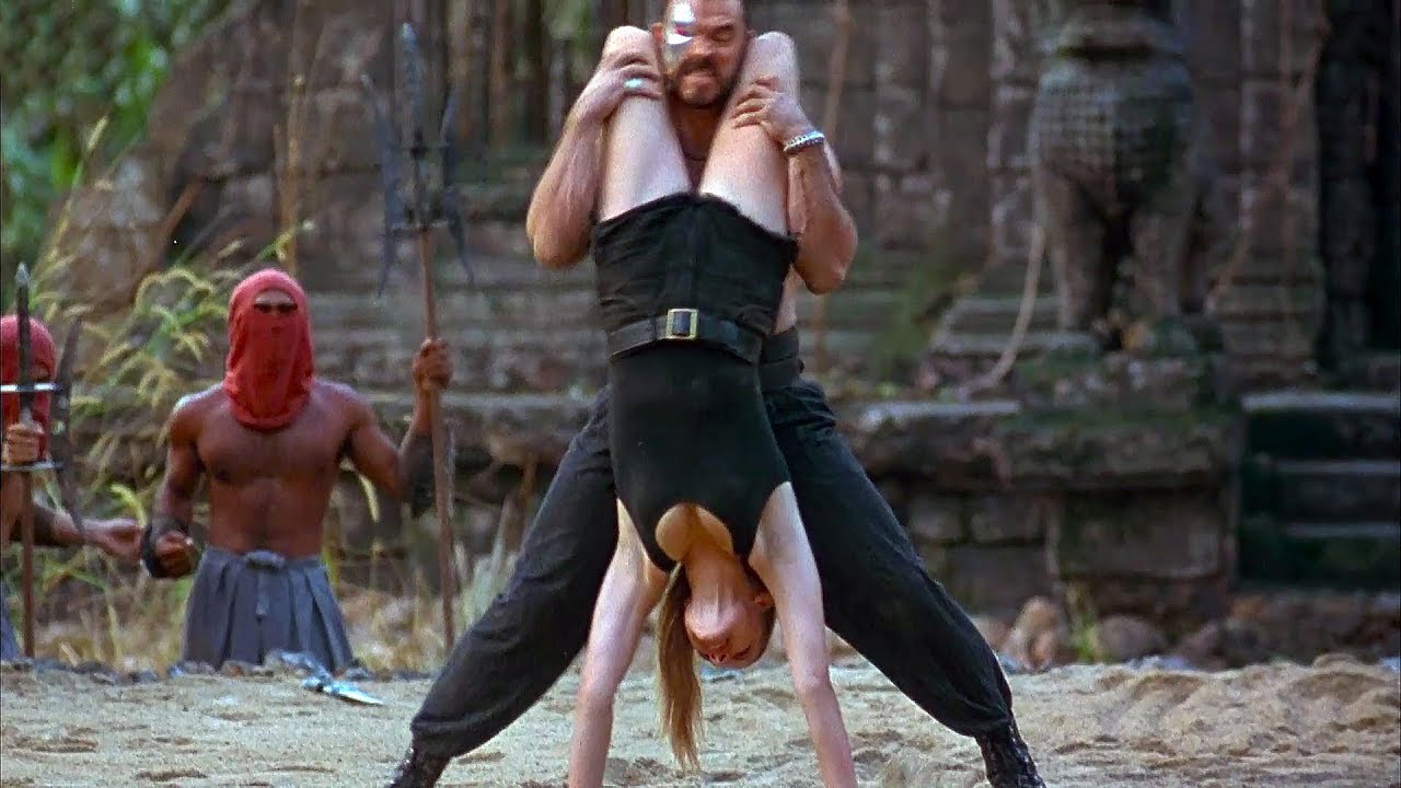 Sonya Blade (Bridgette Wilson) puts Kano (Trevor Goddard) in a thigh chokehold in a still from the 1995 film "Mortal Kombat."