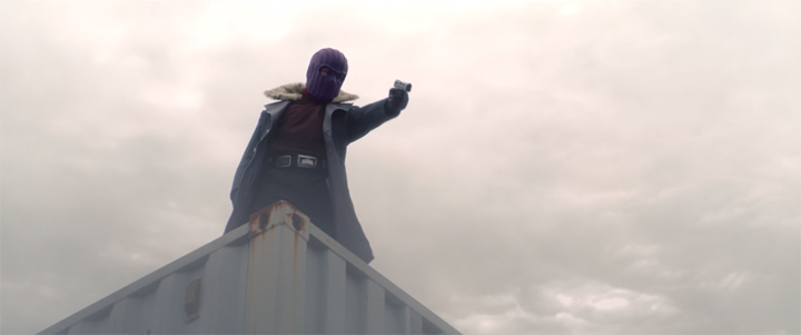 Baron Zemo (Daniel Brühl) aims a gun at a group of bounty hunters in a still from the Disney+ show "The Falcon and the Winter Soldier."