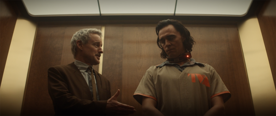 Mobius (Owen Wilson) introduces himself to Loki (Tom Hiddleston) in an elevator in a still from the Disney+ series "Loki."