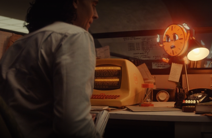 Loki (Tom Hiddleston) learns the history of the TVA from Miss Minutes, an animated clock (voiced by Tara Strong) in a still from the Disney+ show 