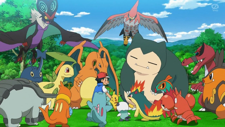 A still from the animated series "Pokemon Journeys" shows the main character, Ash, surrounded by an assortment of Pokemon including Pikachu, Charizard, Snorlax, Buizel, Totodile, Quilava, Oshawatt, and Heracross, among others.