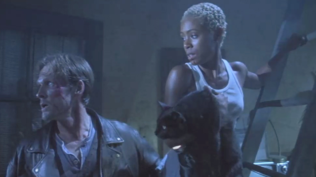 Brayker (William Sadler) and Jeryline (Jada Pinkett) defend themselves against a horde of demons a still from "Tales from the Crypt: Demon Knight."