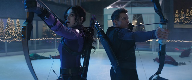 Kate Bishop (Hailee Steinfeld) and Clint Barton (Jeremy Renner) ready arrows in the middle of an ice rink in a still from the Disney+ series "Hawkeye."