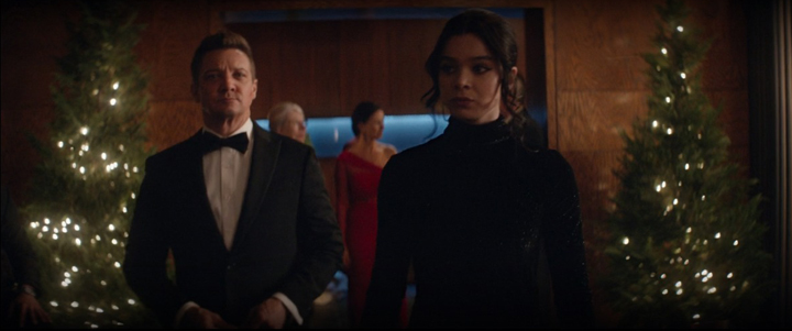 Clint Barton (Jeremy Renner) and Kate Bishop (Hailee Steinfeld) walk into Eleanor Bishop's Christmas party dressed to the nines in a still from the Disney+ show "Hawkeye."