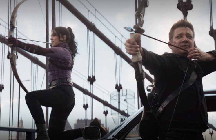 Kate Bishop (Hailee Steinfeld) and Clint Barton (Jeremy Renner) ready arrows at the oncoming Tracksuit Mafia in a still from the Disney+ series 