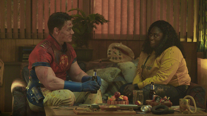 Peacemaker (John Cena) and Adebayo (Danielle Brooks) celebrate their win quietly with a beer in a still from the HBOMax show "Peacemaker."