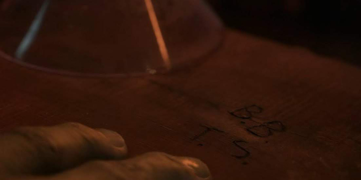 The Hulk looks longingly at the letters "B.B." and "T.S." carved into a wooden bartop.
